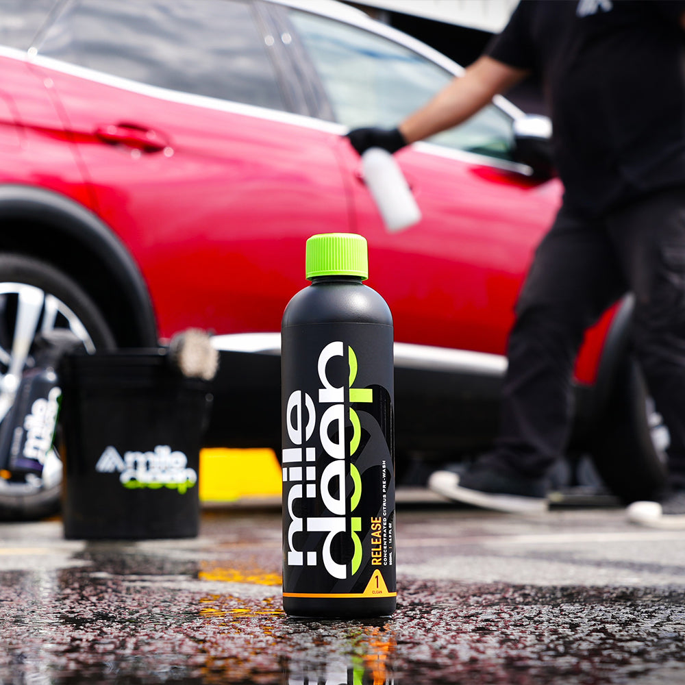 Release concentrated citrus pre-wash for cars with red car in background.